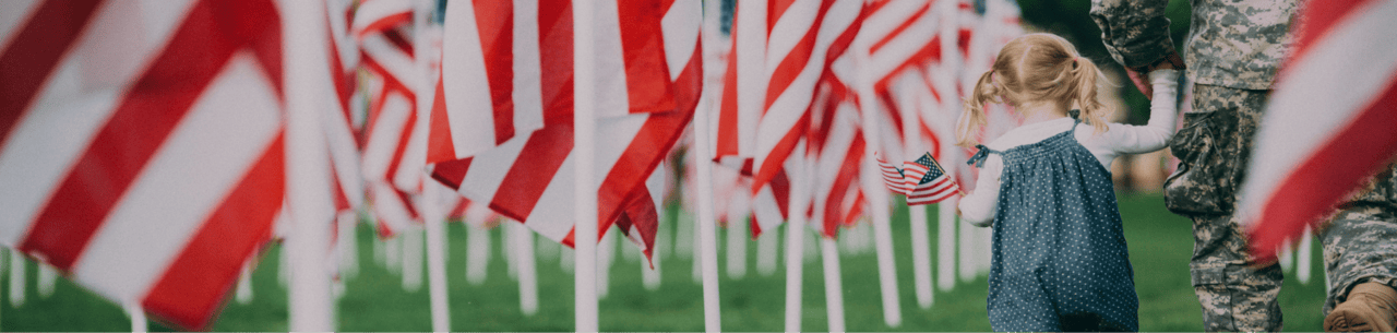 Our Mission: Veteran and child walking through American flags